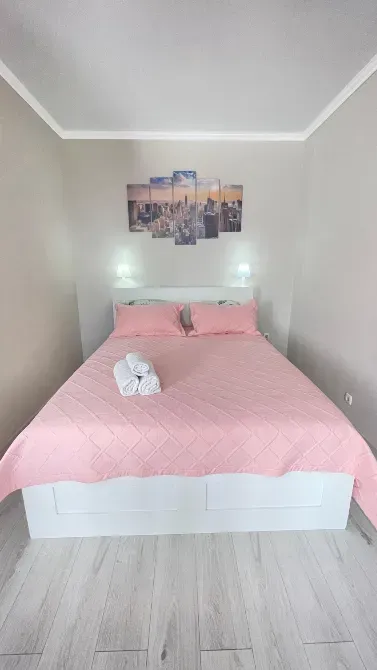 Екі адамға арналған төсек пен розалы түстердегі жастықшалармен ұйықтайтын бөлме