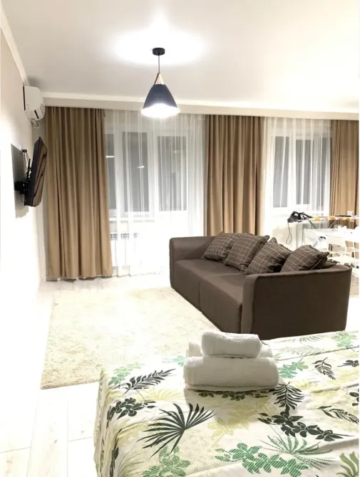 Диван мен жарқын жарықтандыруы бар қонақ бөлме