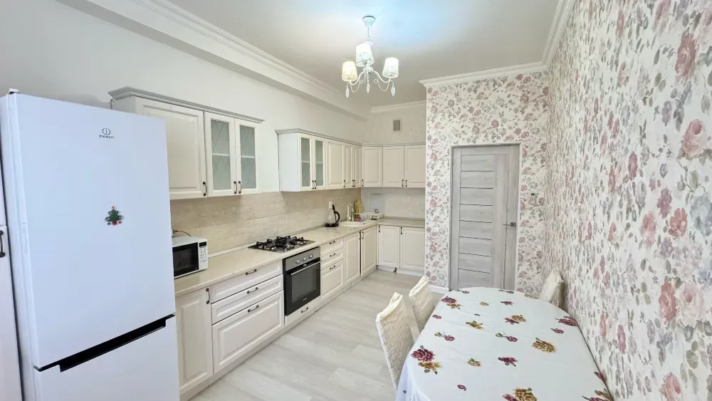 Кухня с белыми шкафами и цветочным обоями