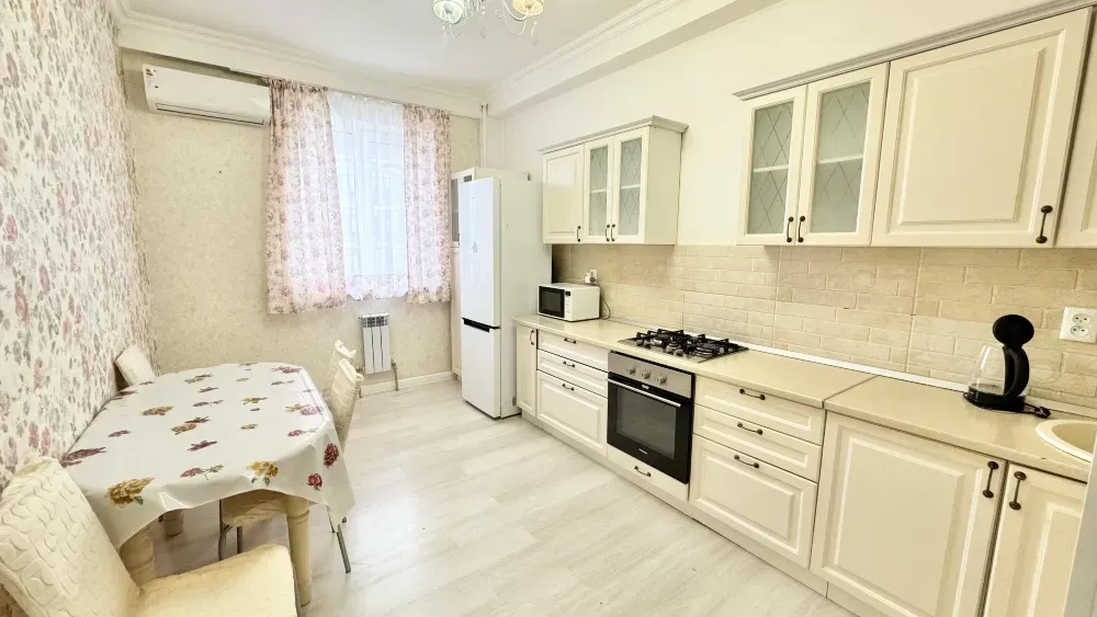 Уютная кухня с обеденным столом и бытовой техникой