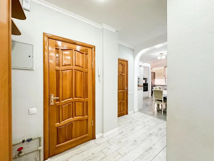 Коридор с деревянными дверями и современным ремонтом