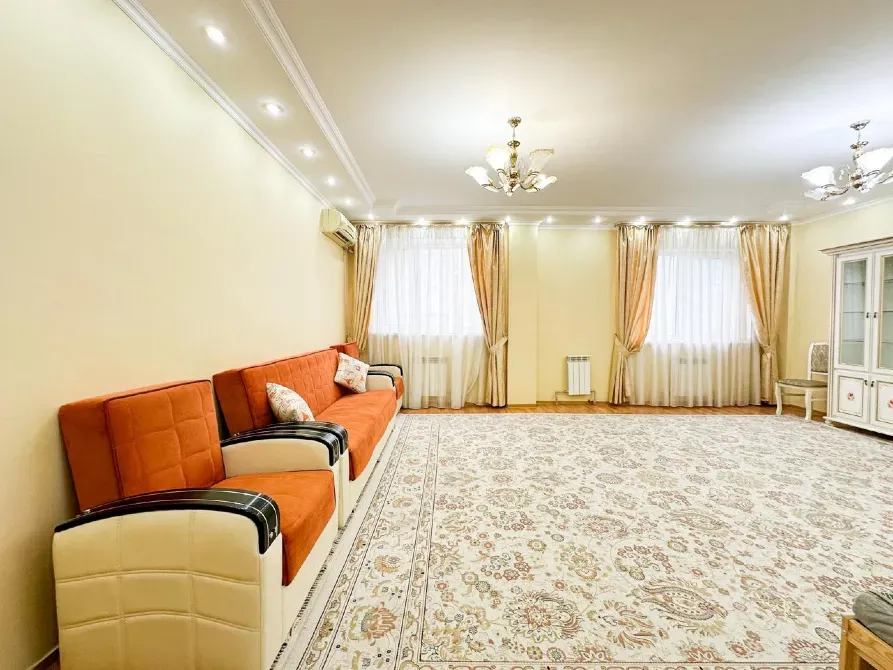 Гостиная с диваном, ковровым покрытием и большими окнами