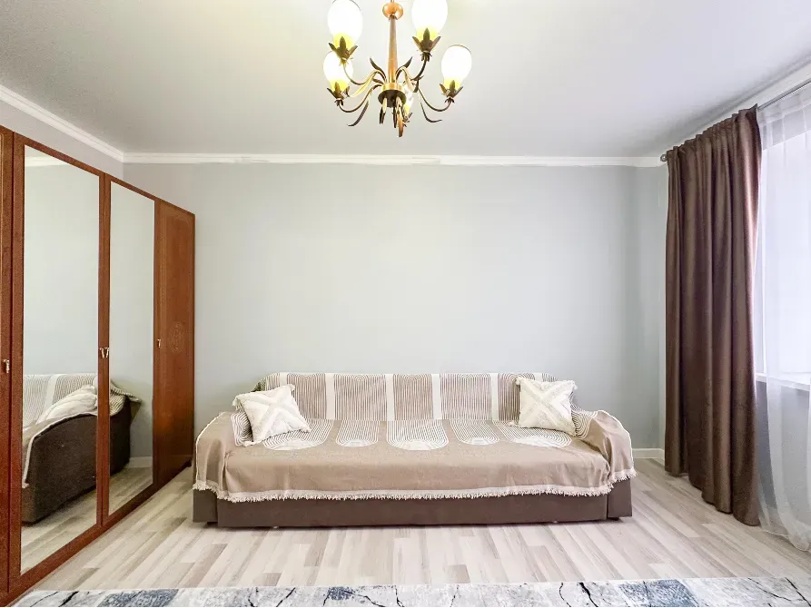 Гостиная с диваном и зеркалым шкафом, ярким светом