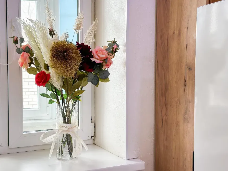 Цветы в вазе на подоконнике, близкий план