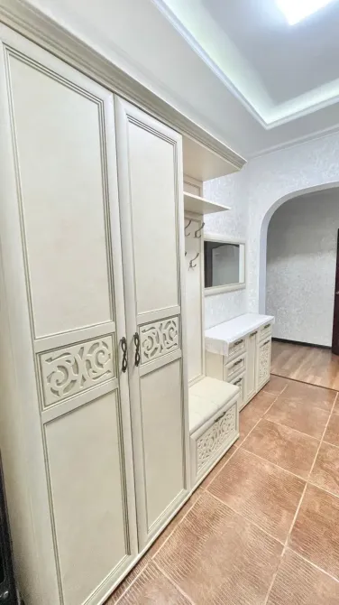 Прихожая с функциональной мебелью и крупным зеркалом