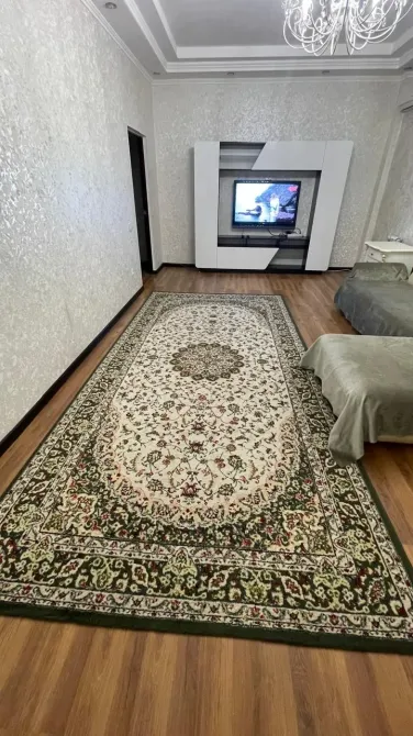 Просторная гостиная с ковром и телевизором