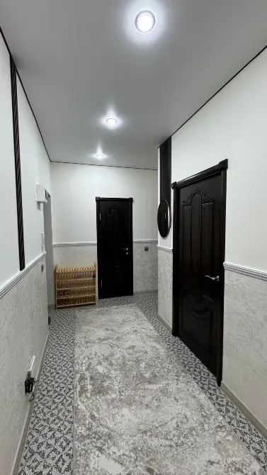 Коридор с дверями и полочками для обуви, оформленный в минималистическом стиле