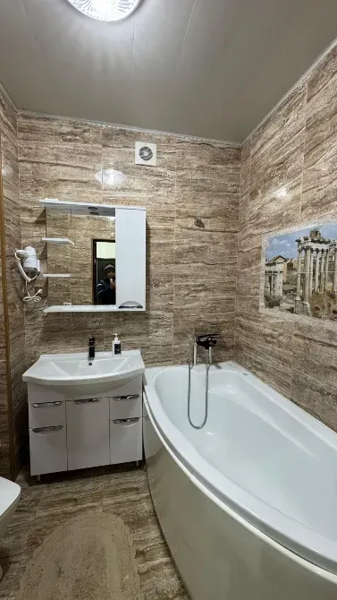 Ванная комната с ванной, зеркалом и современными аксессуарами