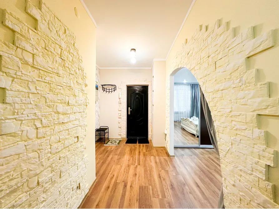 Просторный коридор с арочным проходом и светлыми стенами