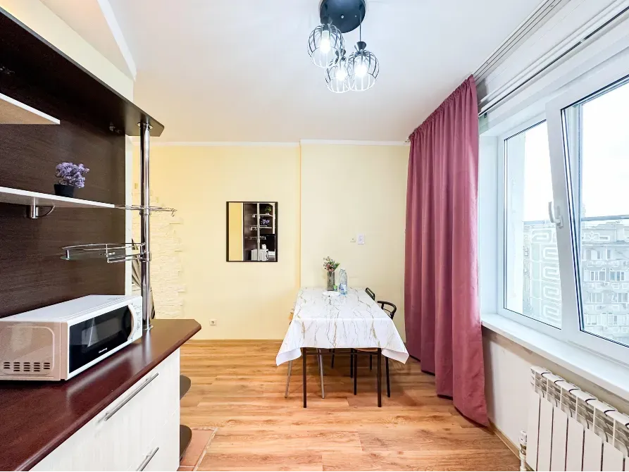 Обеденная зона на кухне с окном и светлыми стенами