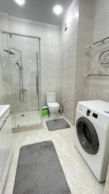 Современная ванная комната с душевой кабиной и стиральной машиной