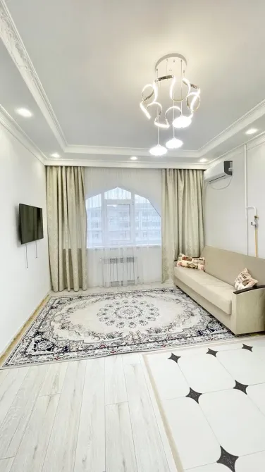 Гостиная с ковром и окнами, пропускающими естественный свет