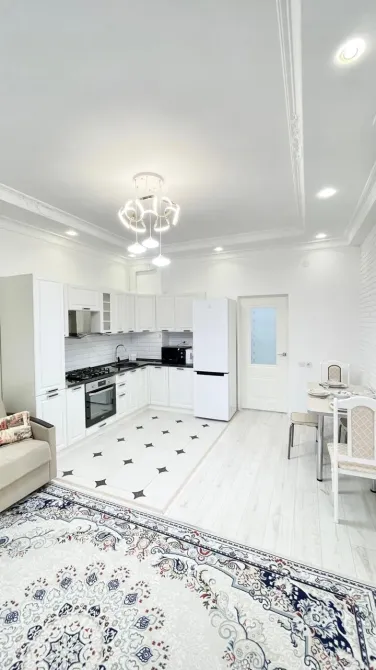 Современная кухня с белыми шкафами и обеденной зоной