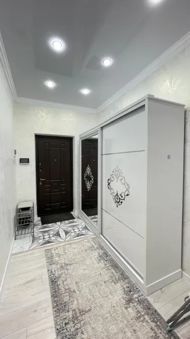 Стильная прихожая с белым шкафом и полами