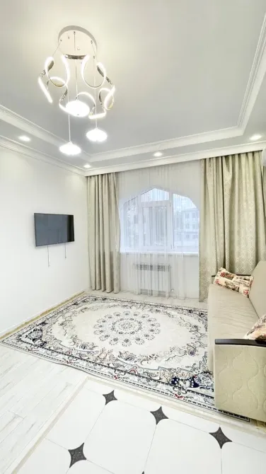 Светлая гостиная с телевизором и уютным диваном