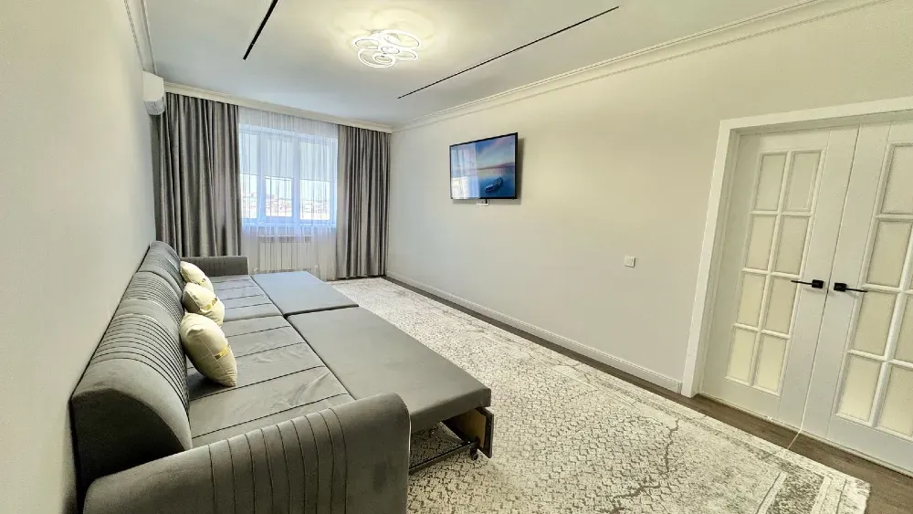 Қонақ бөлмесі жинауға болатын диванмен және үлкен тереземен