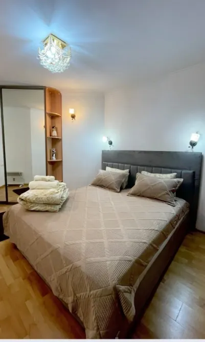 Айна мен тәртіппен жиналған төсектері бар бөлме бұрышы