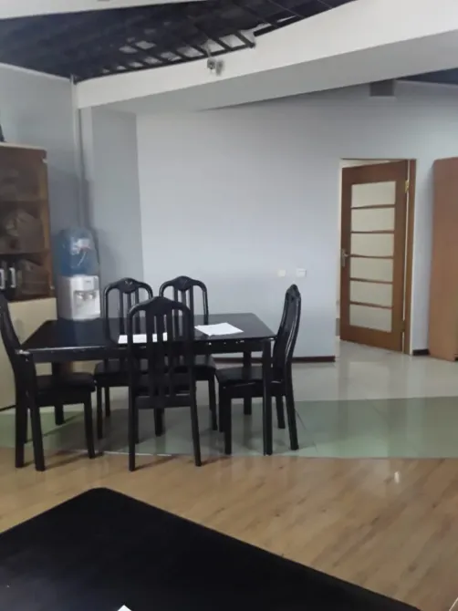 Қара үстел мен орындықтары, айна мен спорттық қабырға жанындағы бөлме интерьері