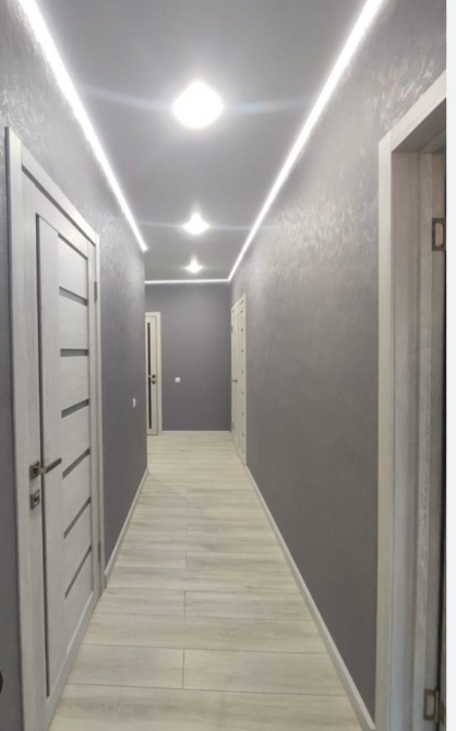 Длинный коридор с современным освещением и дверями