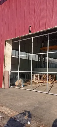 Рабочий в защитной одежде и шлеме для сварки, позируя на строительной площадке