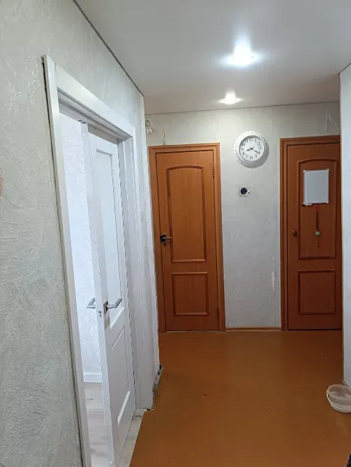 Коридор, есіктер мен қабырғада сағатпен