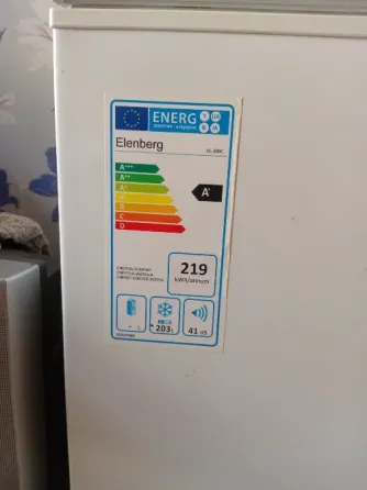 Холодильник с открытой крышкой и этикеткой энергопотребления