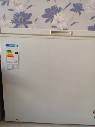 Холодильник с открытой крышкой и этикеткой энергопотребления