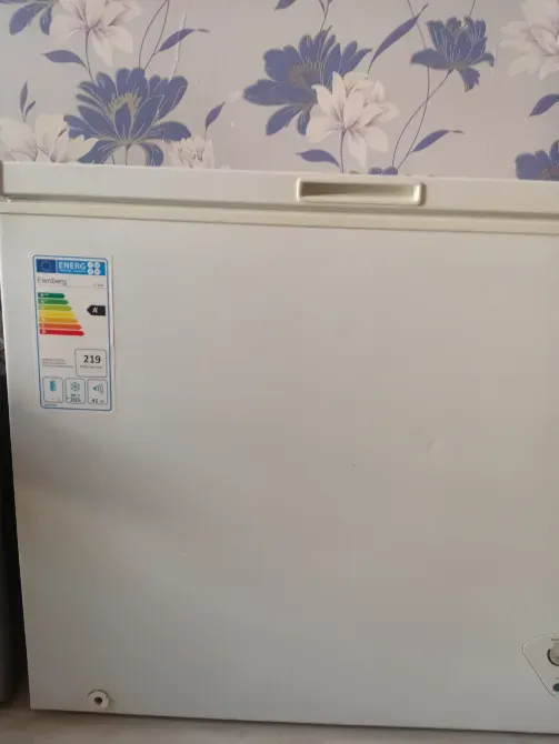 Холодильник с открытой крышкой и этикеткой энергопотребления