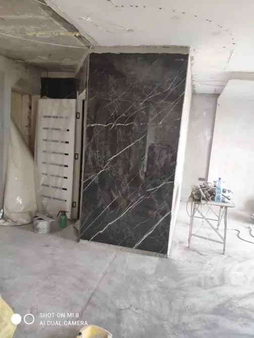 Қара мәрмәр қабырғалары мен әрлеуі бар құрылыс алаңы.