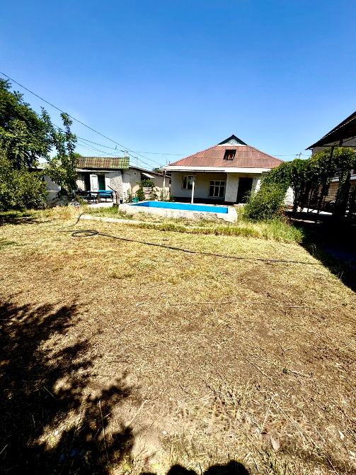 Открытое пространство с ухоженным участком и домом на заднем плане