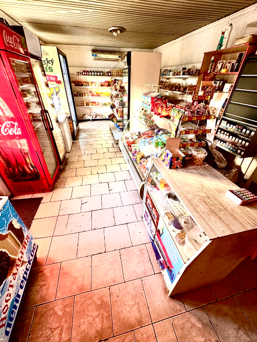 Проход в магазине с различными продуктами и холодильниками