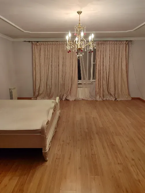 Спальня с длинными шторами и светильником в центре