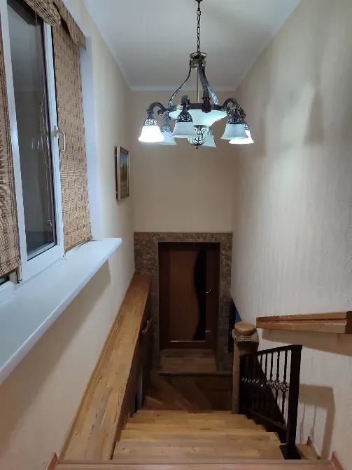 Лестница с деревянными перилами и светильником