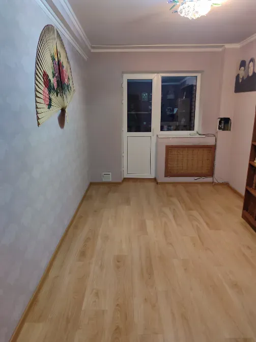 Комната с деревянным полом и выходом на балкон