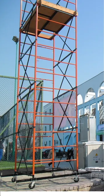 Красная строительная леса на площадке, стоит на колесах