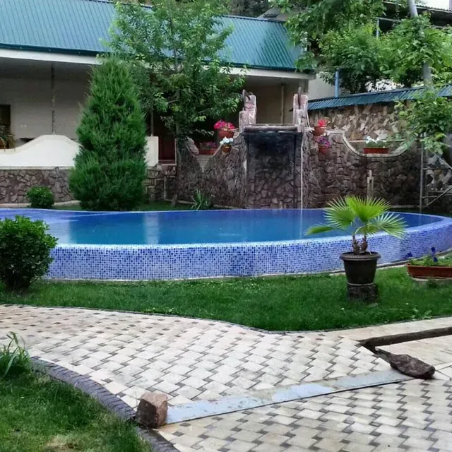 Бассейн с фонтаном и растениями вокруг