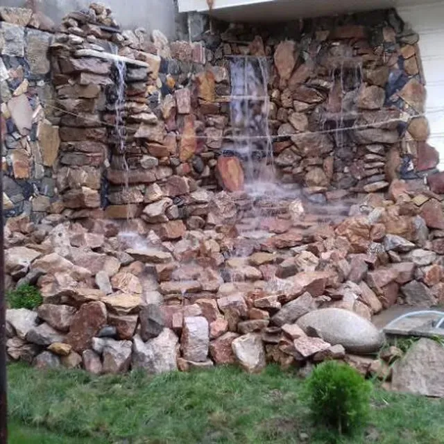 Водопад на каменной стене в саду