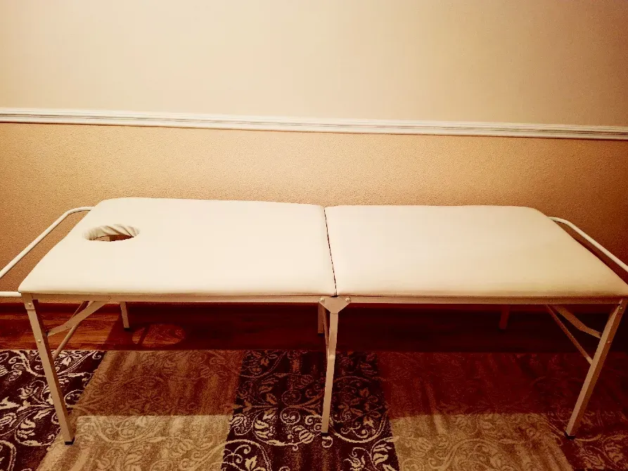 Массажный стол с выемкой для лица, расположенный на половом покрытии