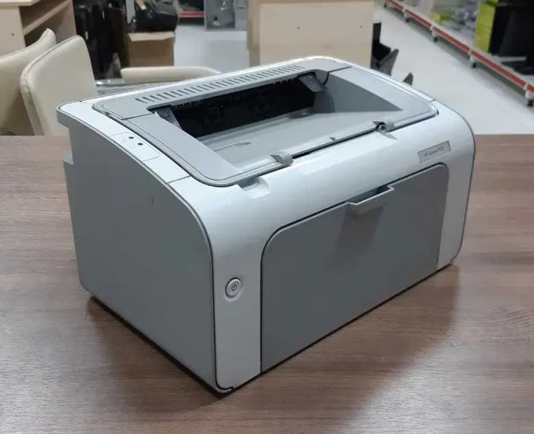 Ағаш үстелде орналасқан принтер