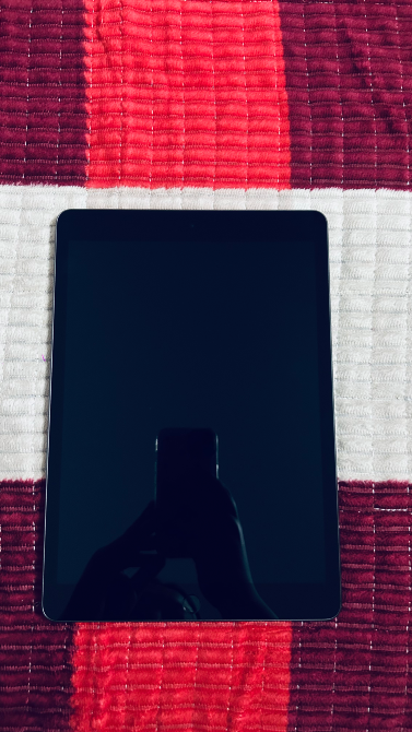 IPad беті қызыл-ақ квадратты мата үстінде, суретсіз