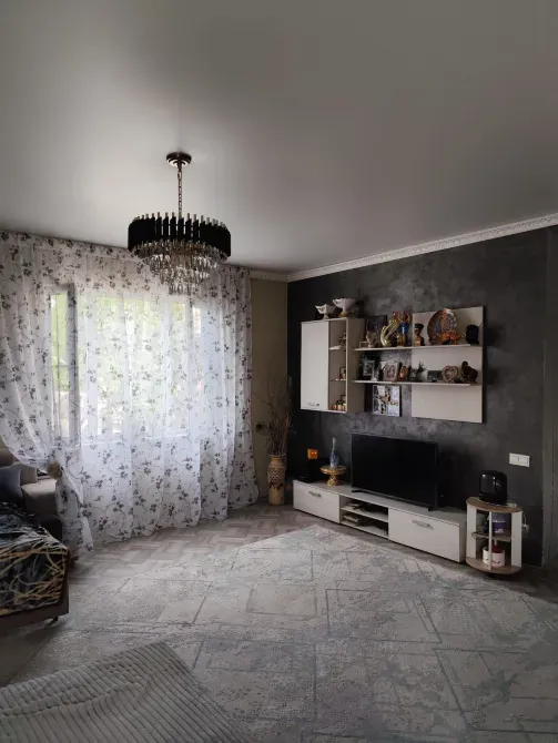 Светлая гостиная с окнами и телевизором