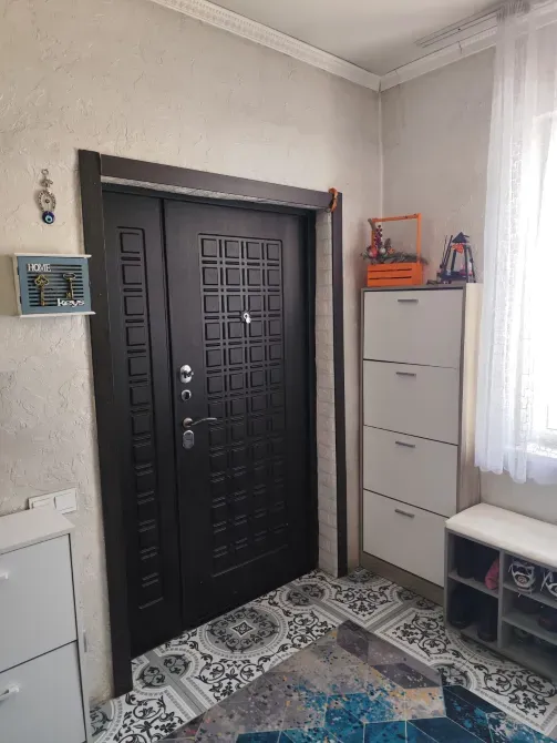 Прихожая с чёрной дверью и шкафами для обуви