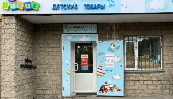 Детский магазин с яркой вывеской и входной дверью