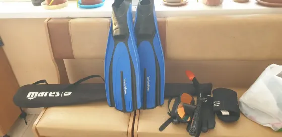 Пара ласт Mares синего цвета, маска для подводного плавания, трубка и перчатки для дайвинга на диване