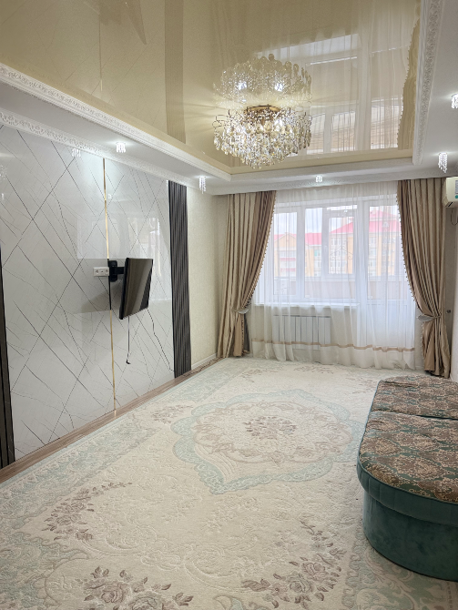 Современная гостиная с большим зеркальным потолком и комфортабельной мебелью