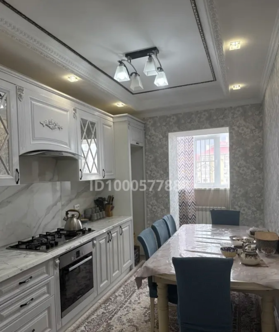 Стильная кухня с современными бытовыми приборами и обеденным столом