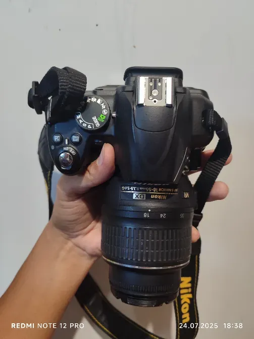 камера Nikon с объективом в руках