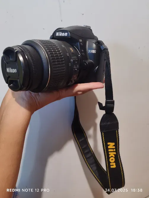 камера Nikon D3000 в руках