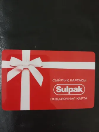 Подарочная карта Sulpak с красным дизайном и белым бантом