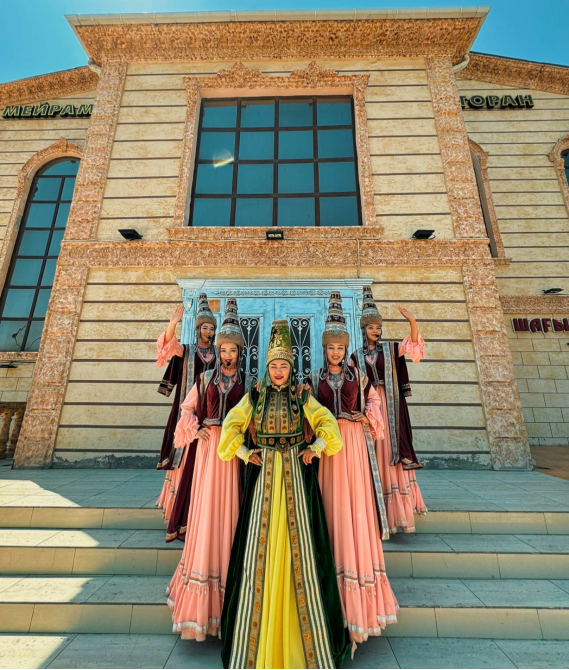 Национальные танцоры в костюмах на лестнице здания